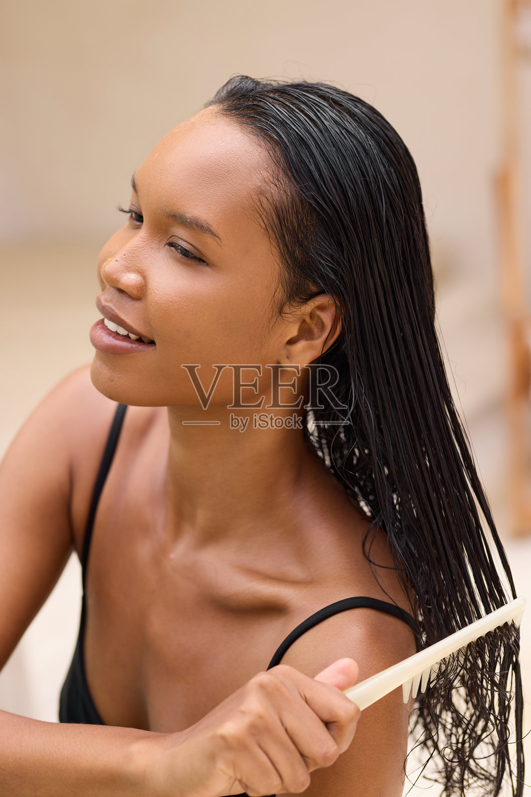 年轻女性在舒适的家居环境中轻柔地梳理湿发照片摄影图片