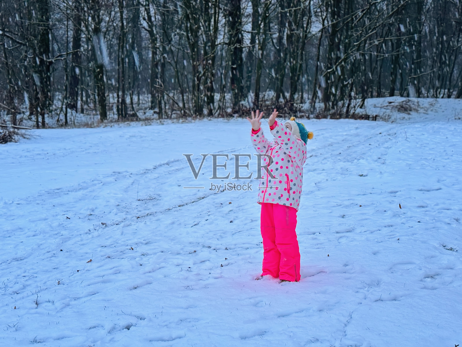 有趣的小女孩在美丽的冬季公园里玩得很开心。快乐的学生在雪中玩耍，对降雪和冬季活动感到快乐。照片摄影图片