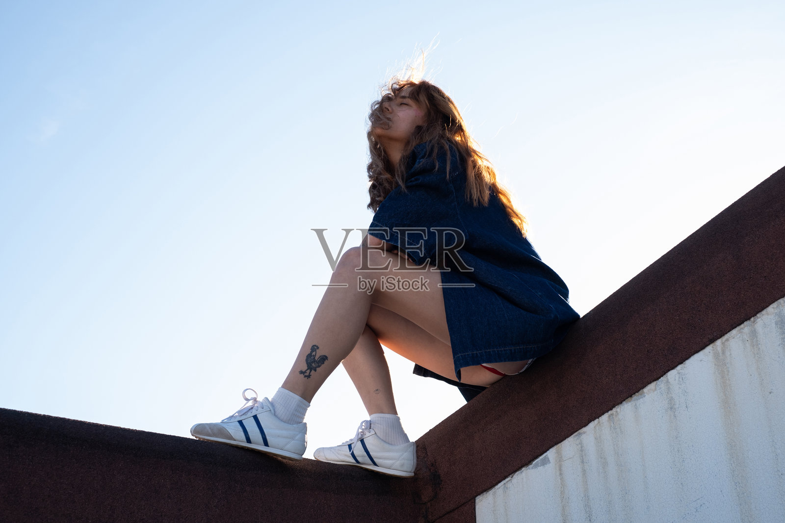 年轻的金发女子在屋顶上照片摄影图片