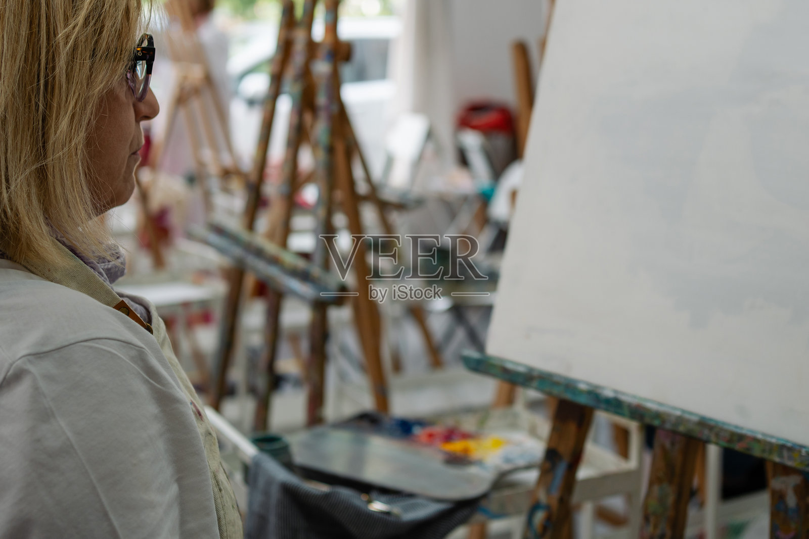 女性艺术家在艺术工作室准备在空白画布上作画照片摄影图片