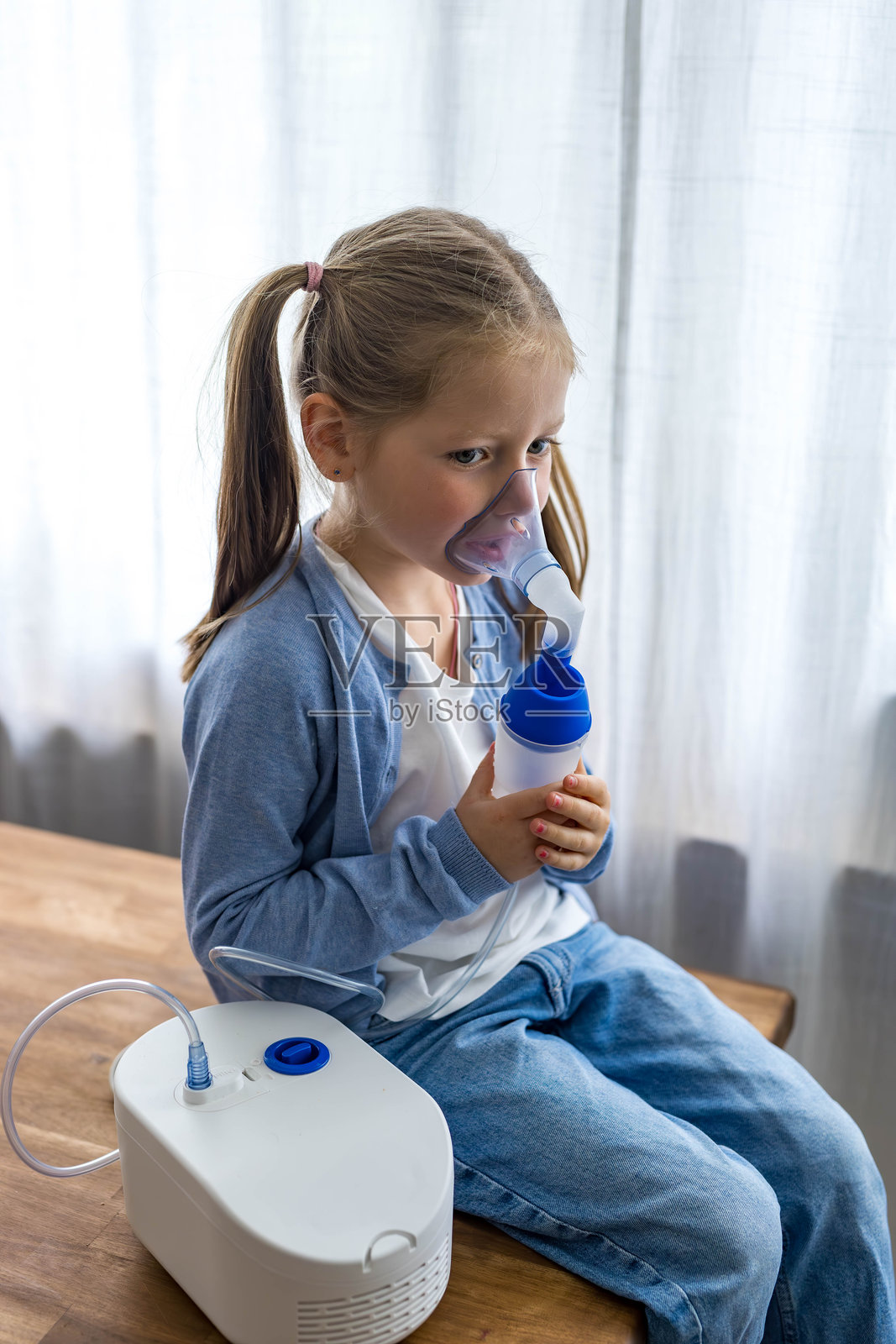 一个5岁的小女孩在家使用雾化器，深呼吸以帮助她的呼吸健康。照片摄影图片