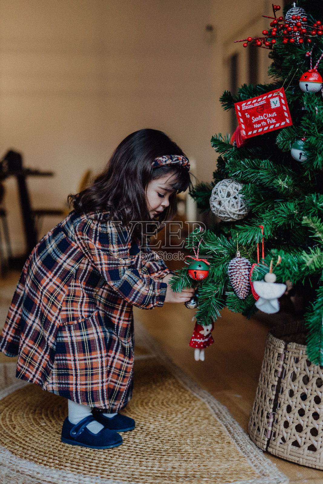 可爱的女孩正在用装饰品装饰圣诞树照片摄影图片