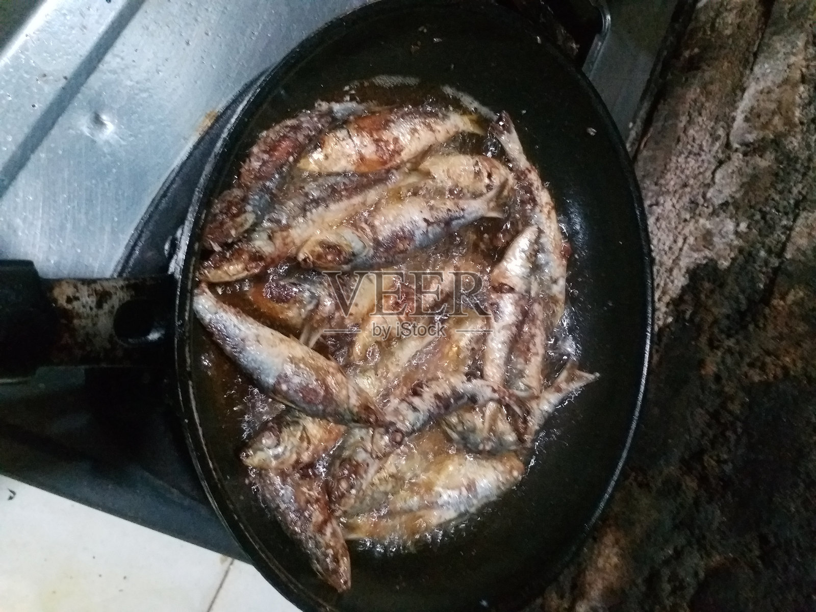 在深色背景上用特氟龙煎炸的凤尾鱼照片摄影图片