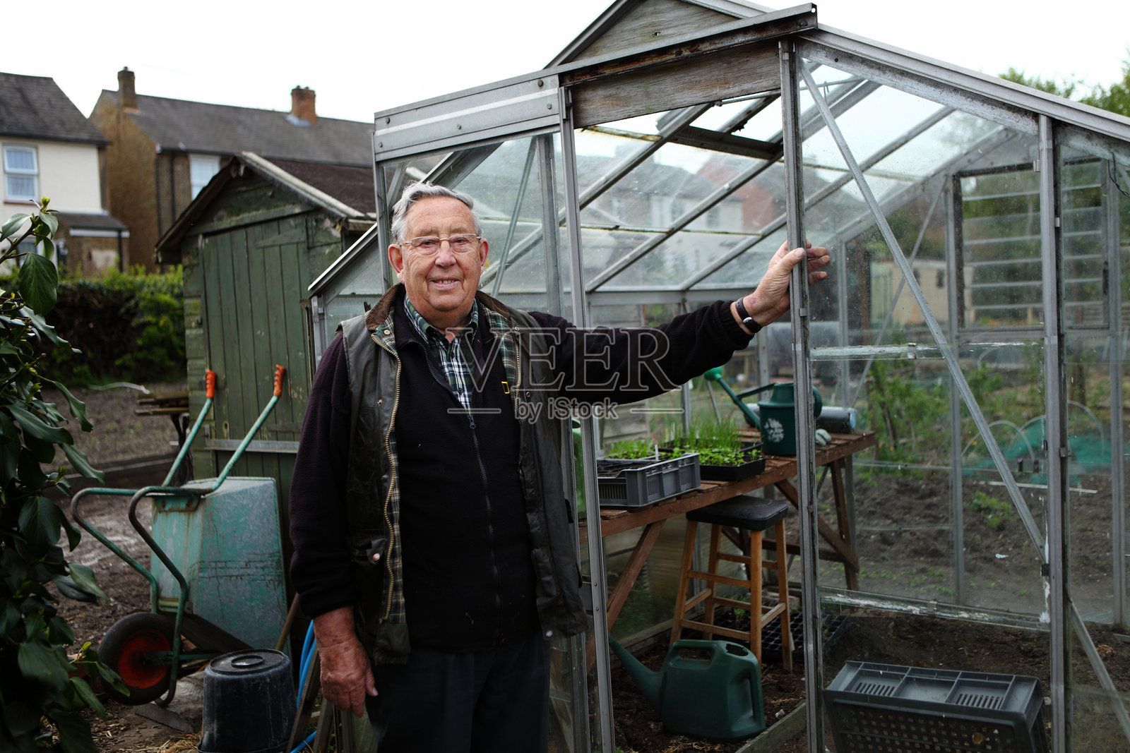 老年人在他的温室前照片摄影图片