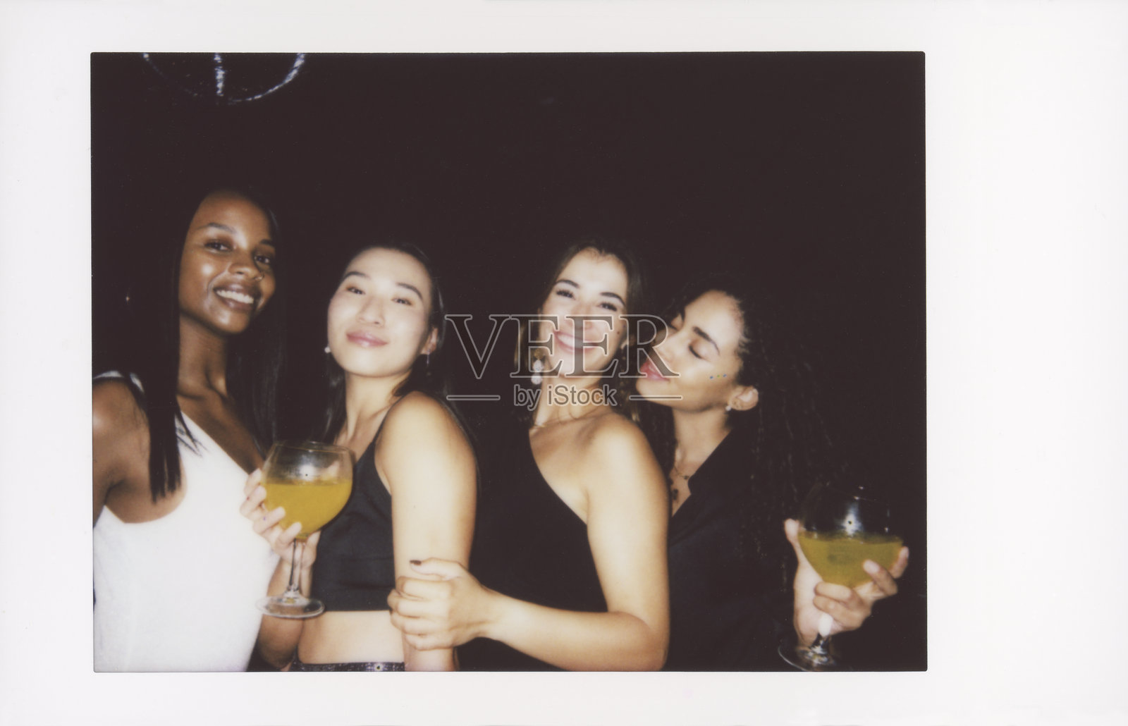 一群快乐的朋友在复古风格的照片中庆祝，手中举着鸡尾酒照片摄影图片