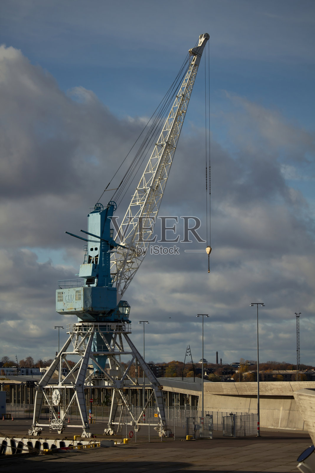 蓝色港口起重机在蓝天和云朵的背景下。照片摄影图片