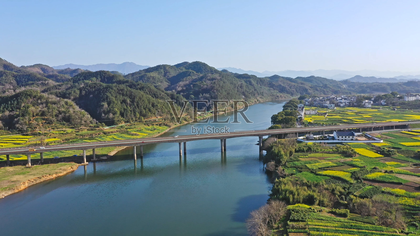 中国安徽省的油菜花田中的高速公路，徽州风格建筑，亚洲。照片摄影图片