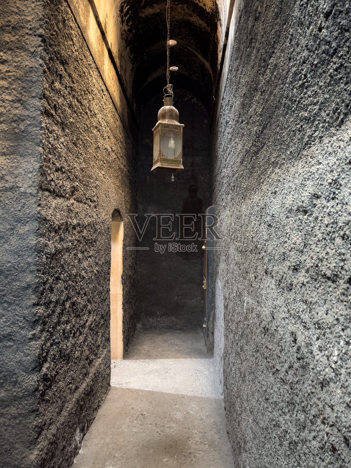 一盏悬挂的灯笼照亮了历史建筑中阴暗的石头走廊照片摄影图片