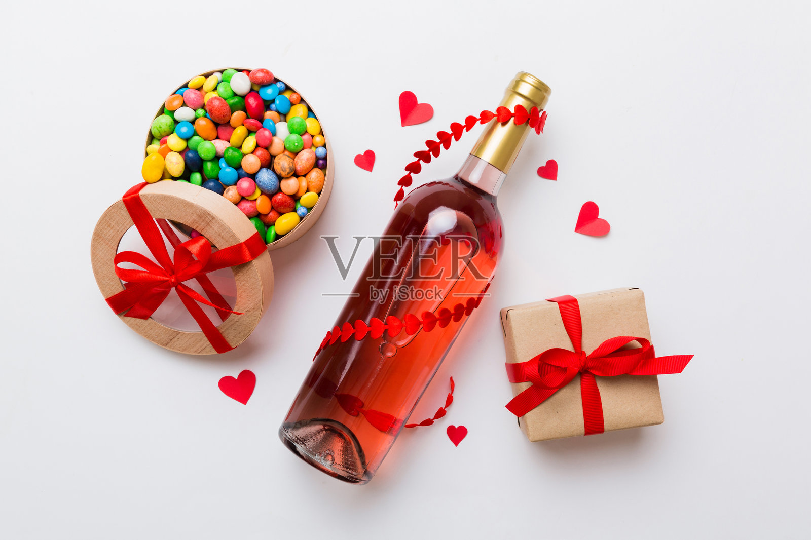 情人节红酒瓶与礼物和巧克力的彩色背景。心形巧克力礼盒的俯视图，留有空白空间。照片摄影图片