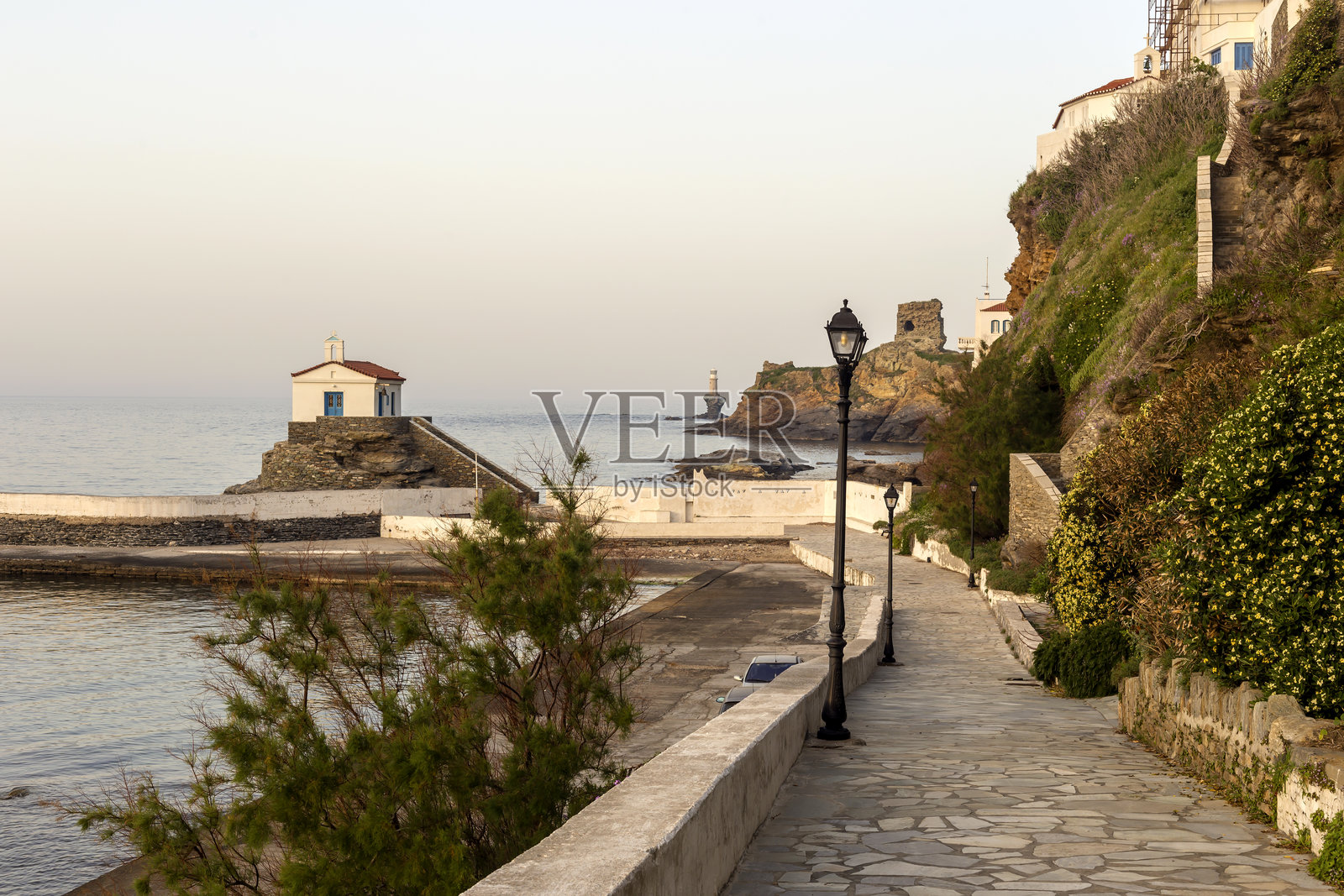 小镇灯塔、堡垒、教堂和大海的景观（希腊，安德罗斯岛，基克拉泽斯群岛）照片摄影图片