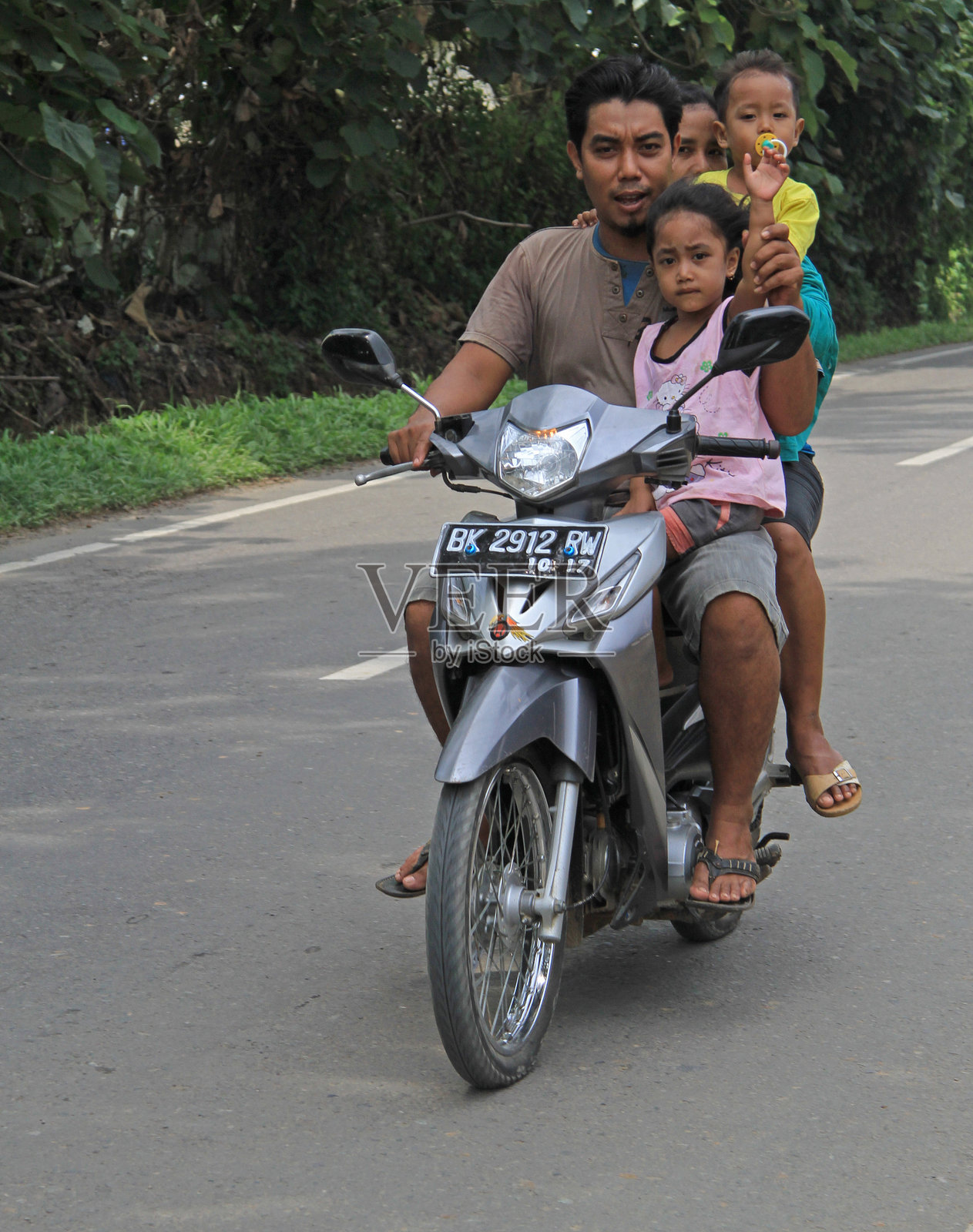 四个人在印度尼西亚骑摩托车。照片摄影图片