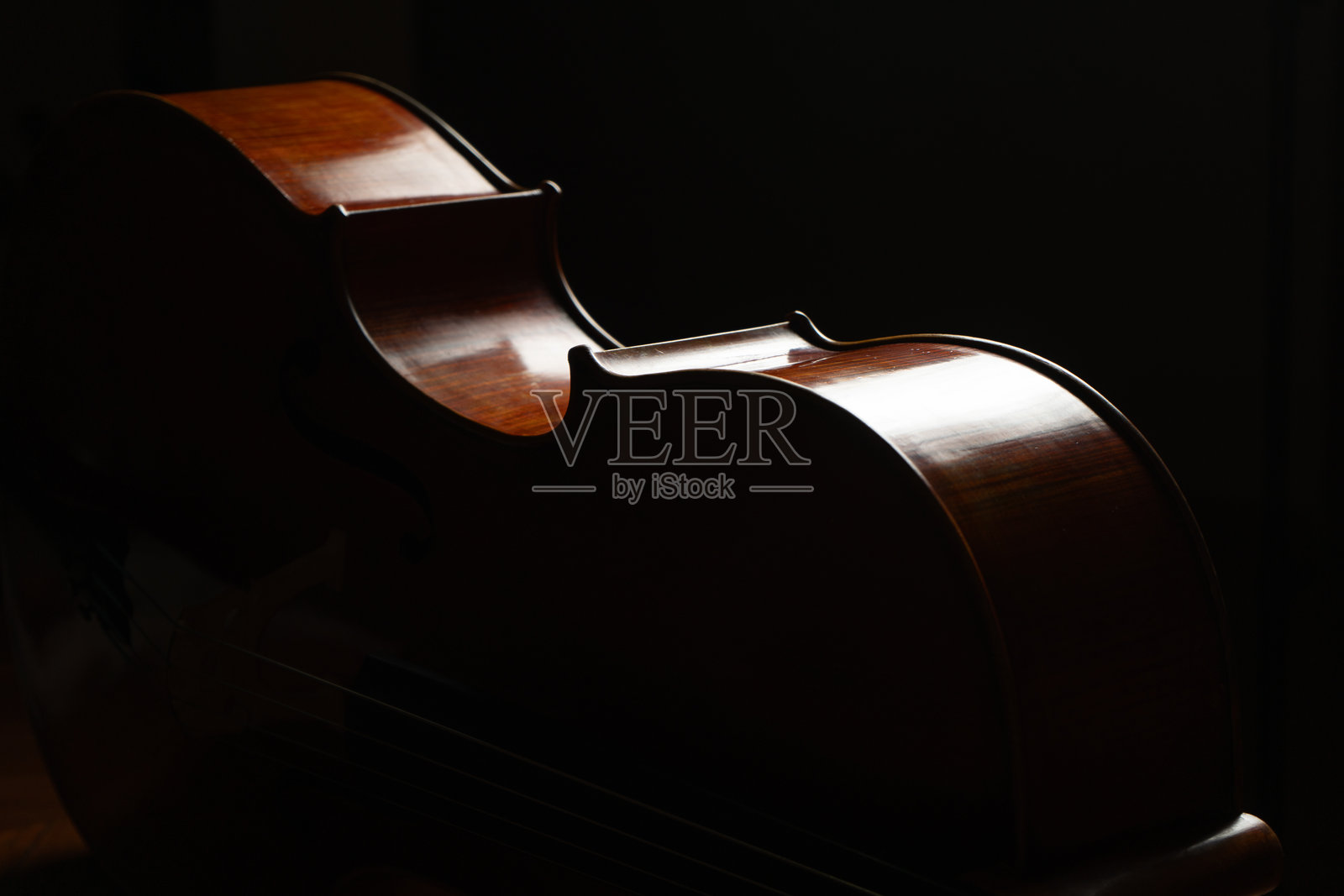 大提琴特写，古典音乐背景，经典弦乐器，小提琴纹理木质背景，低调工作室摄影，背光和黑色背景照片摄影图片