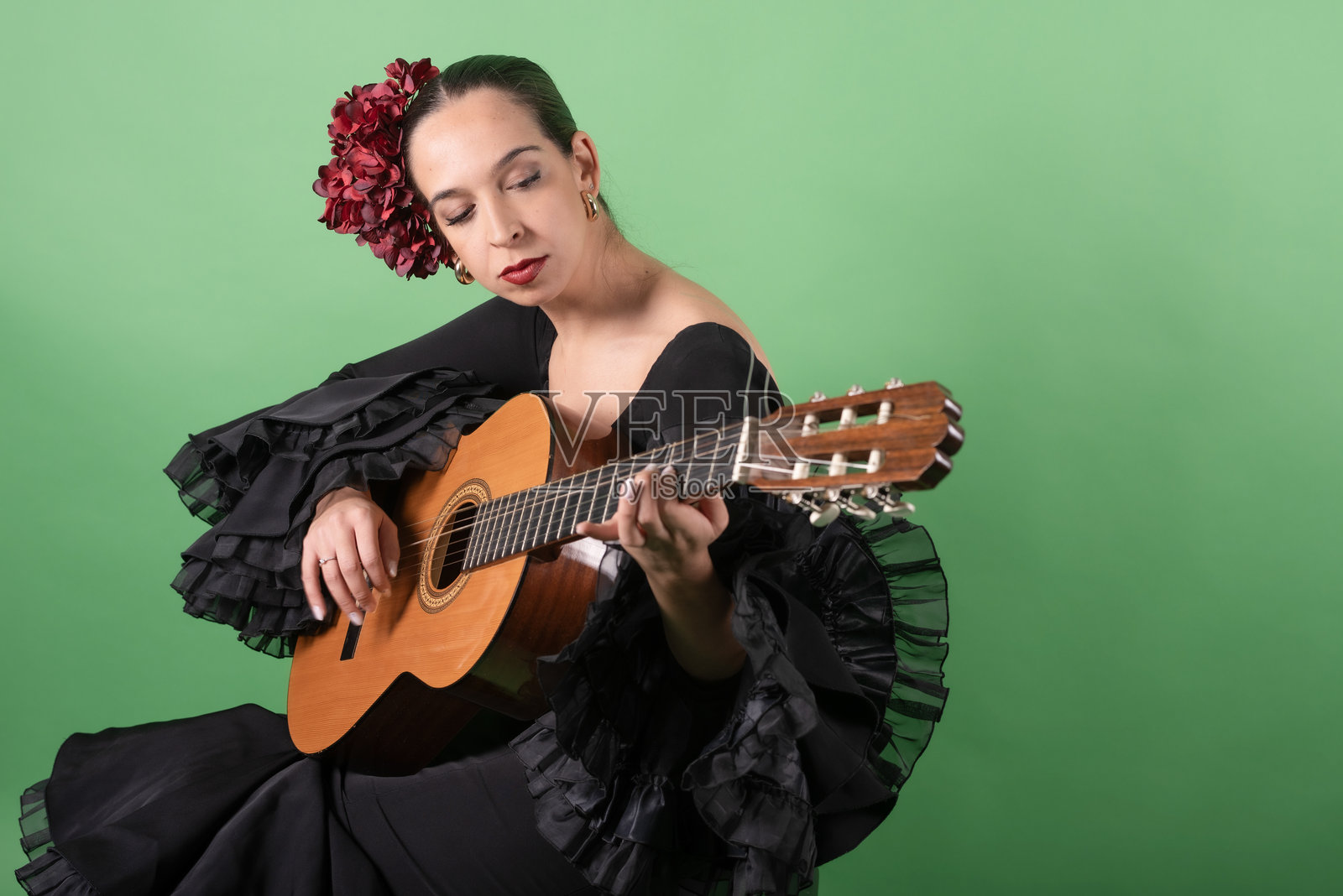 优雅的西班牙弗拉门戈女郎弹奏着木吉他照片摄影图片