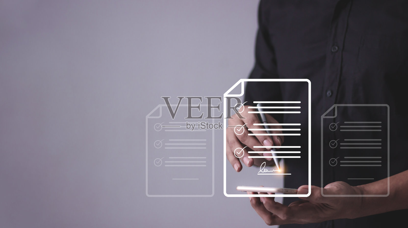 年轻男子手持智能手机和笔，正在触碰签署在线商业合同，合同签署，电子签名，数字文件，未来智能合同照片摄影图片