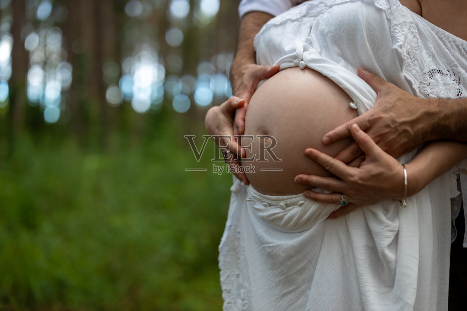 期待新生儿的准父母在自然户外环境中的孕妇摄影。男性和女性情侣开始新的家庭。照片摄影图片