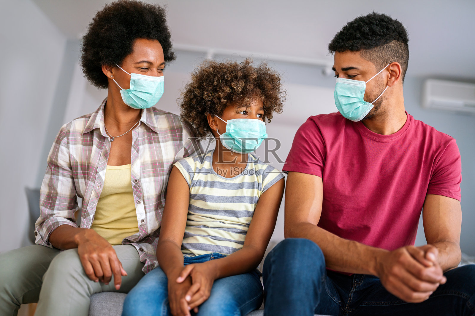 家庭在冠状病毒和流感疫情期间佩戴口罩。病毒和疾病防护，COVID照片摄影图片