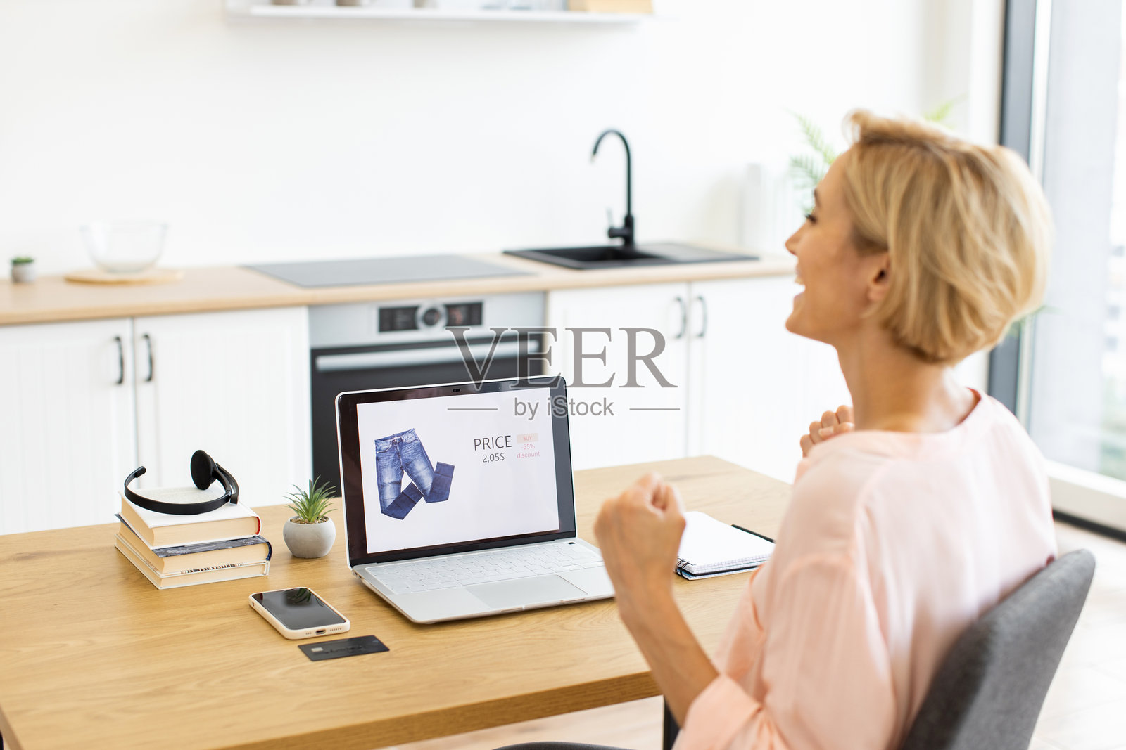 快乐的女人兴奋地在网上购物买衣服照片摄影图片