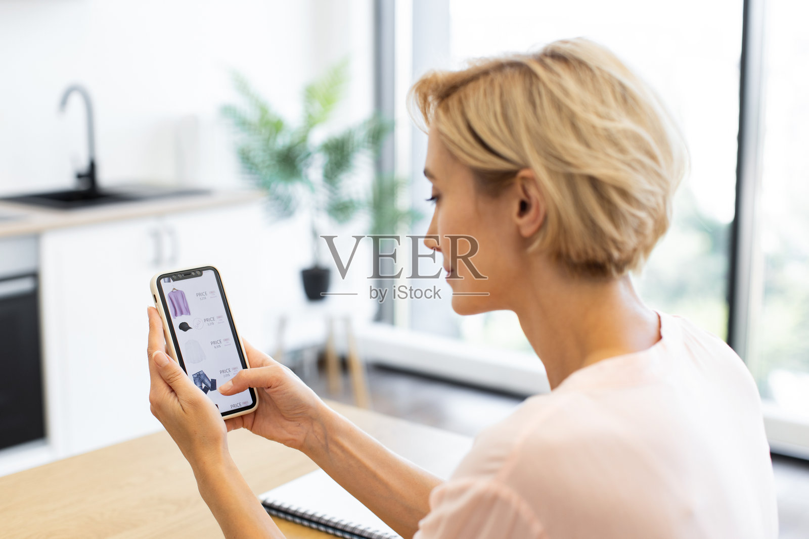 白人女性使用智能手机在线购物购买衣物照片摄影图片