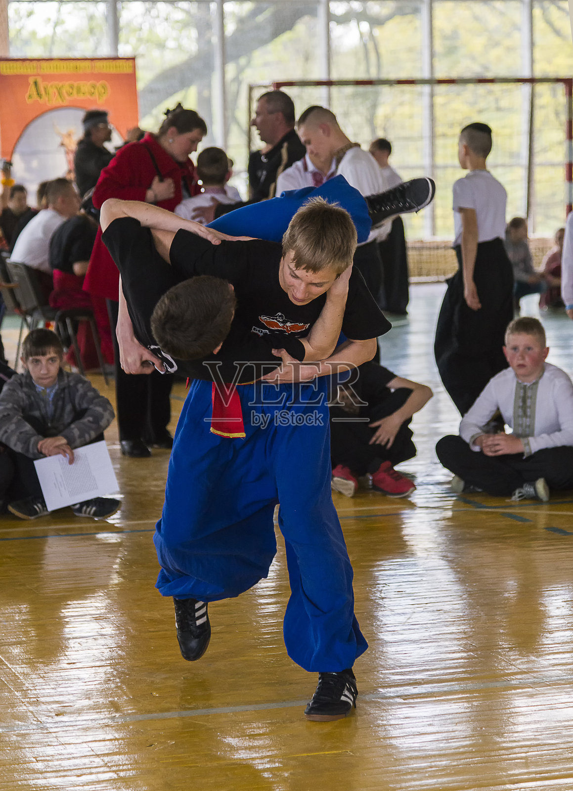 男孩将对手摔倒在大腿上照片摄影图片