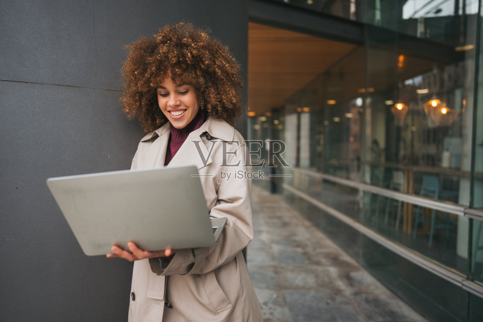美丽的年轻女性在使用笔记本电脑并微笑照片摄影图片