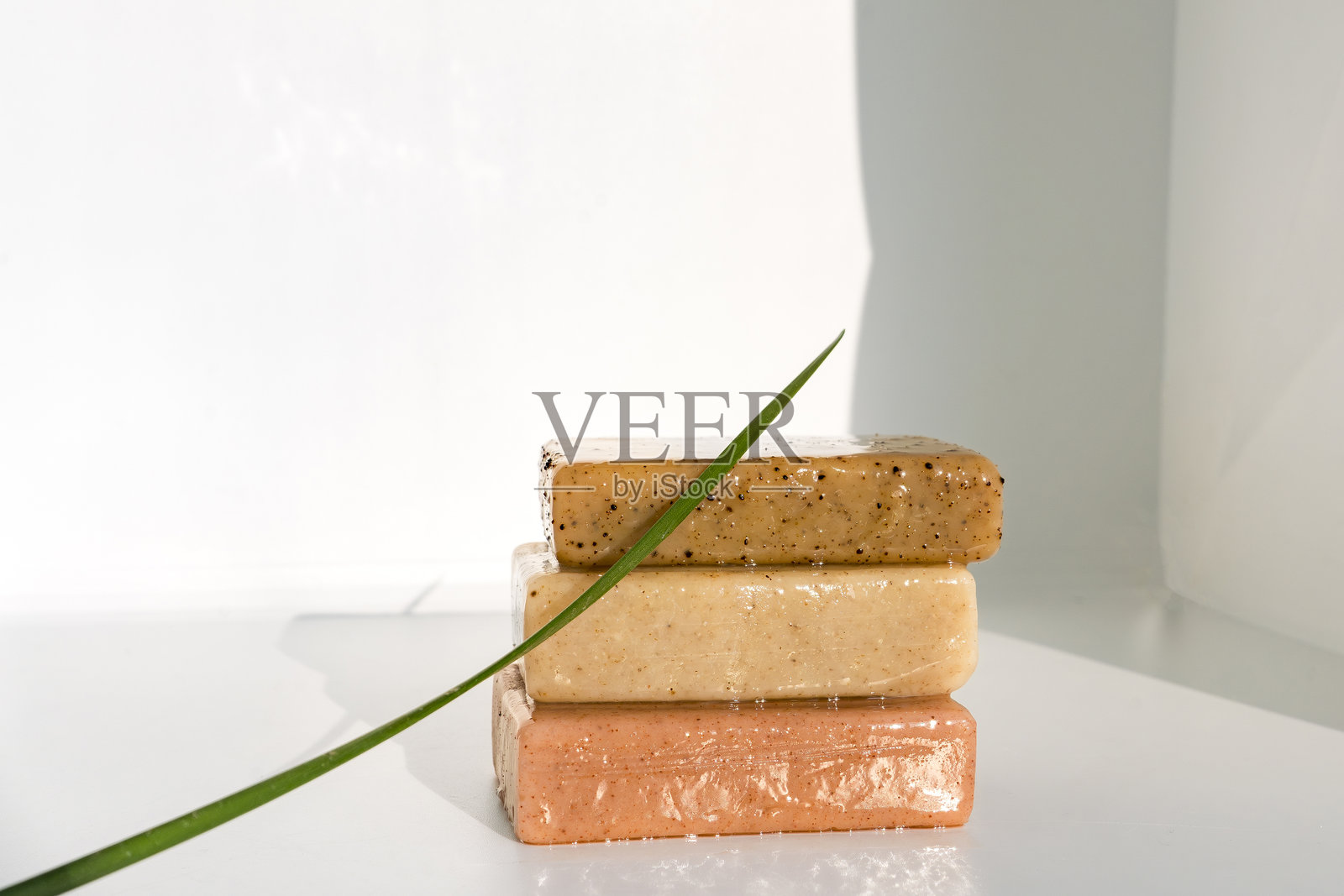 草本香皂模型，背景为白色，搭配植物和叶子，美容健康概念照片摄影图片