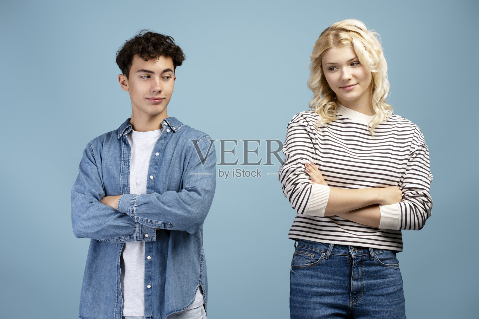 微笑的情侣肖像，男朋友和女朋友穿着休闲服，双臂交叉。照片摄影图片