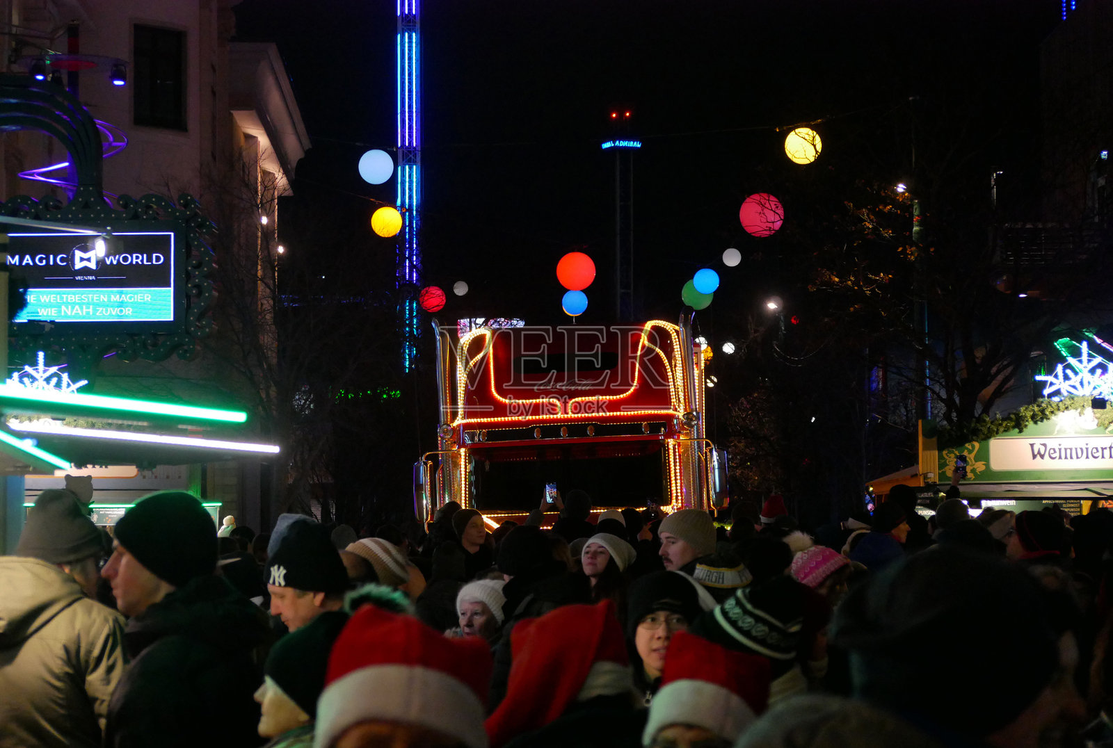 维也纳普拉特游乐园，摩天轮广场前方的可口可乐卡车。圣诞市场的游客们在观看并拍摄这辆传统的圣诞可口可乐卡车。照片摄影图片