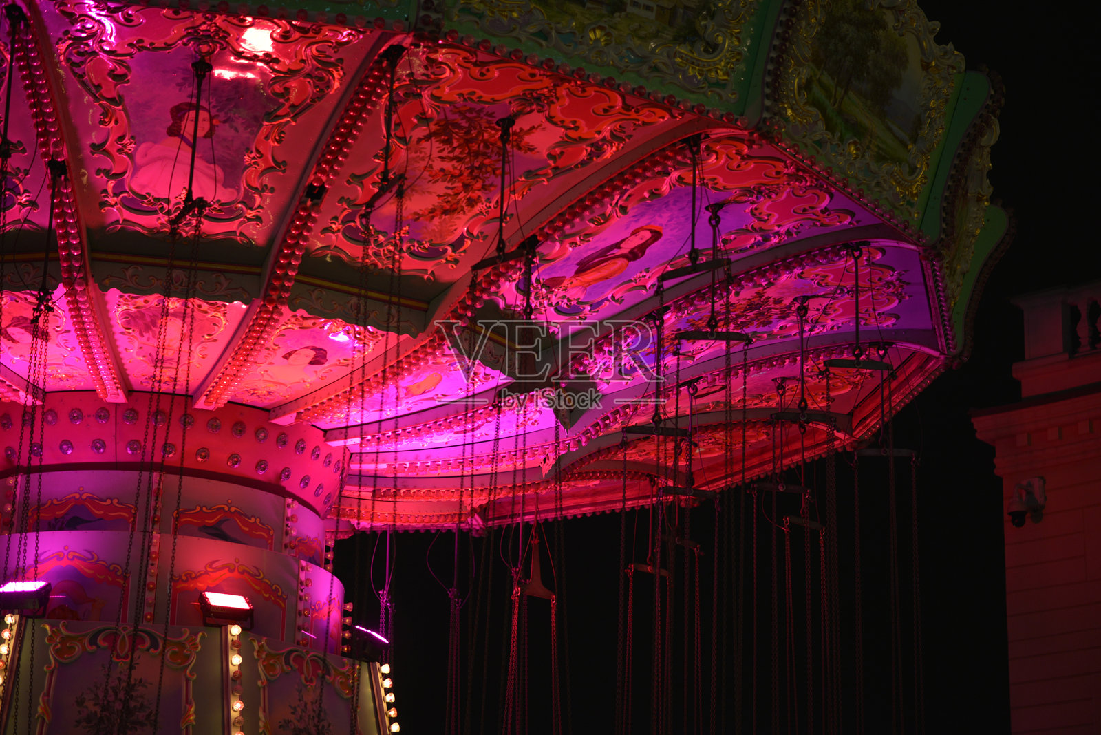 维也纳普拉特游乐园的复古风格旋转木马,红色灯光在傍晚时分闪烁。照片摄影图片