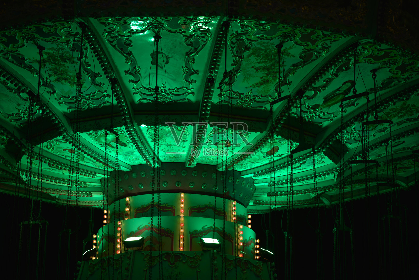 维也纳普拉特游乐园的复古风格旋转木马，绿色灯光在傍晚时分闪烁。照片摄影图片