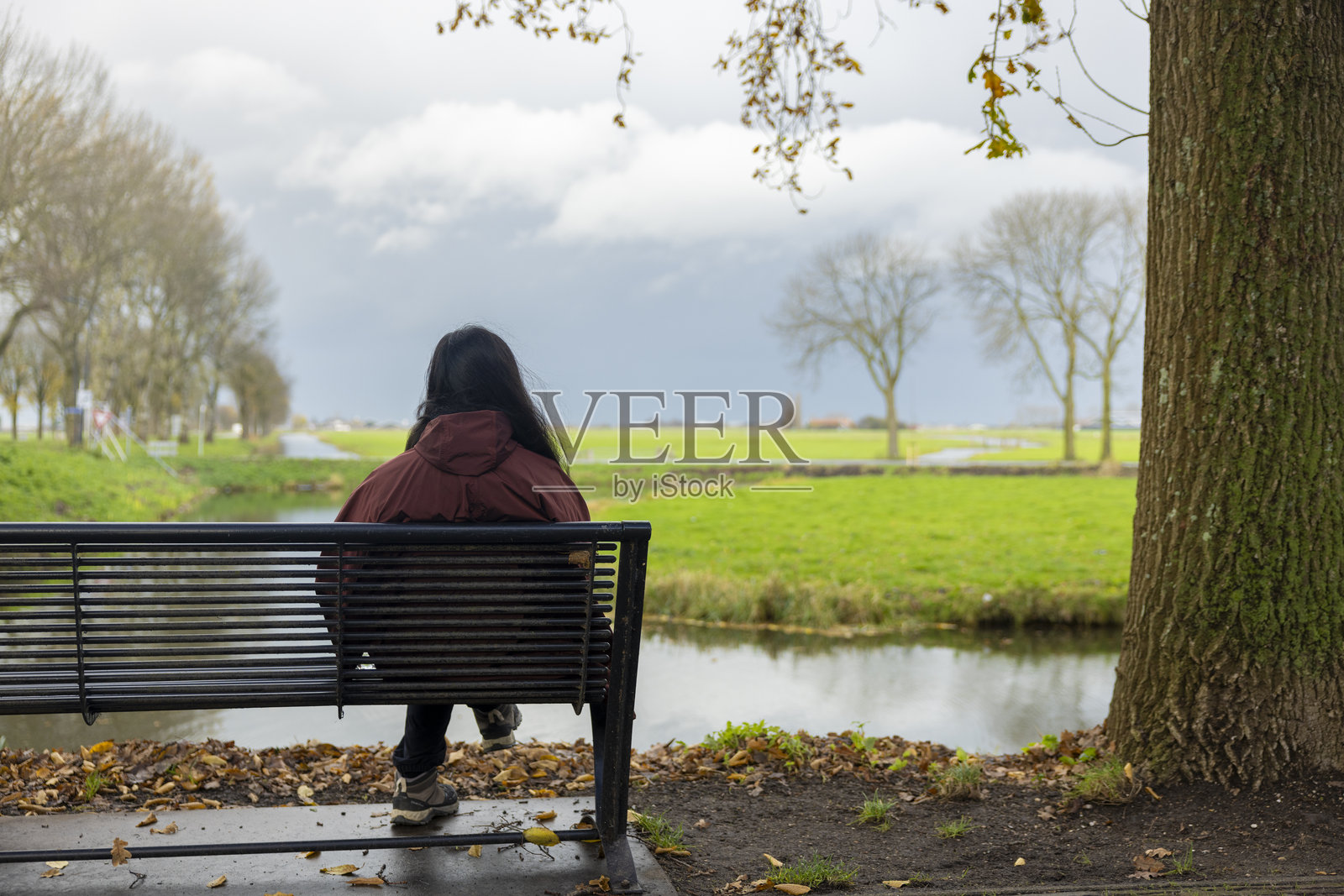 女人独自坐在公共公园里照片摄影图片