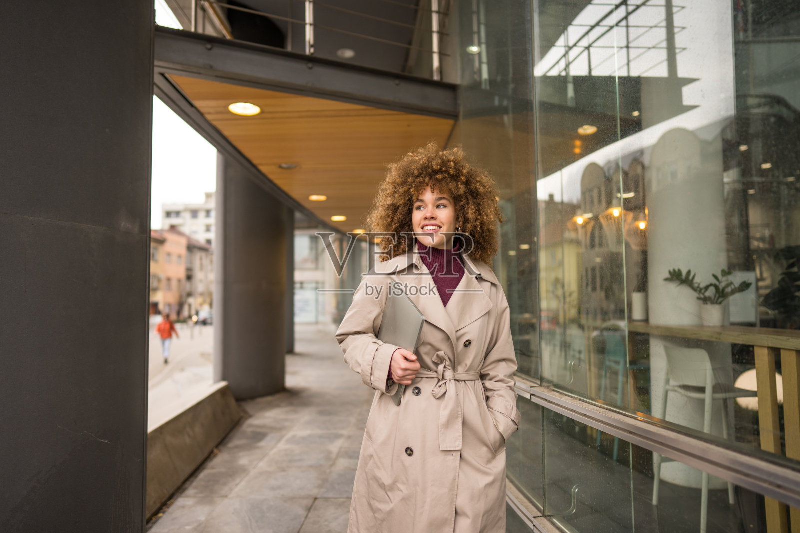 一位女性在城里携带着笔记本电脑。照片摄影图片