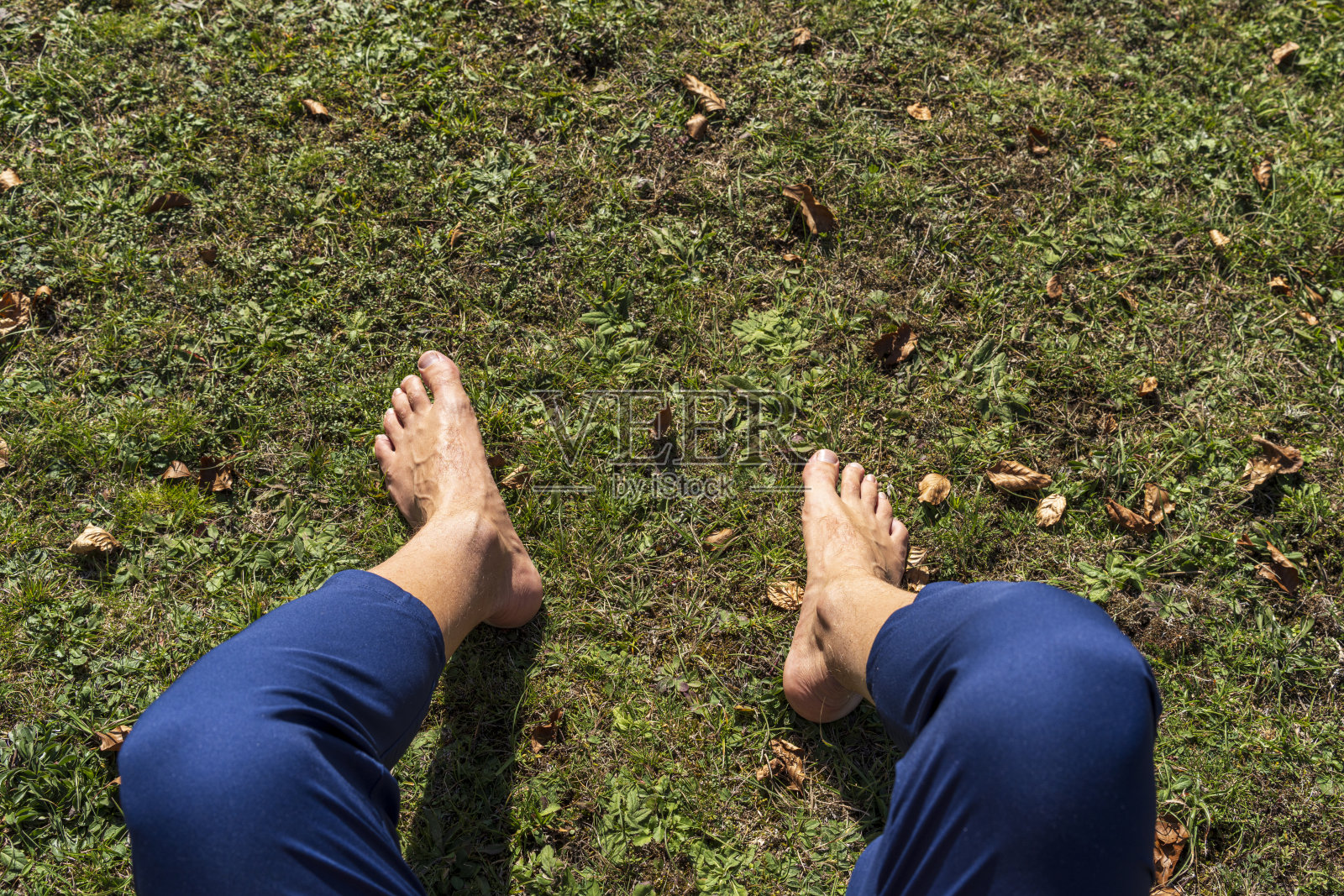 赤脚坐在地面上的男人，与大自然连接。大自然中的接地和土壤概念。照片摄影图片