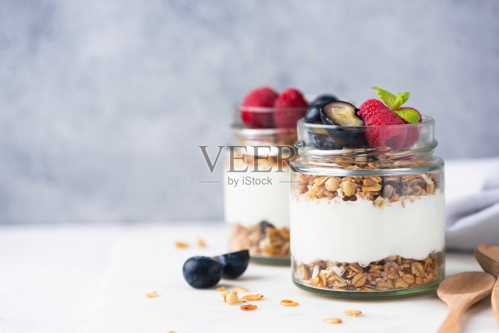 希腊酸奶杯配格兰诺拉麦片和新鲜浆果照片摄影图片