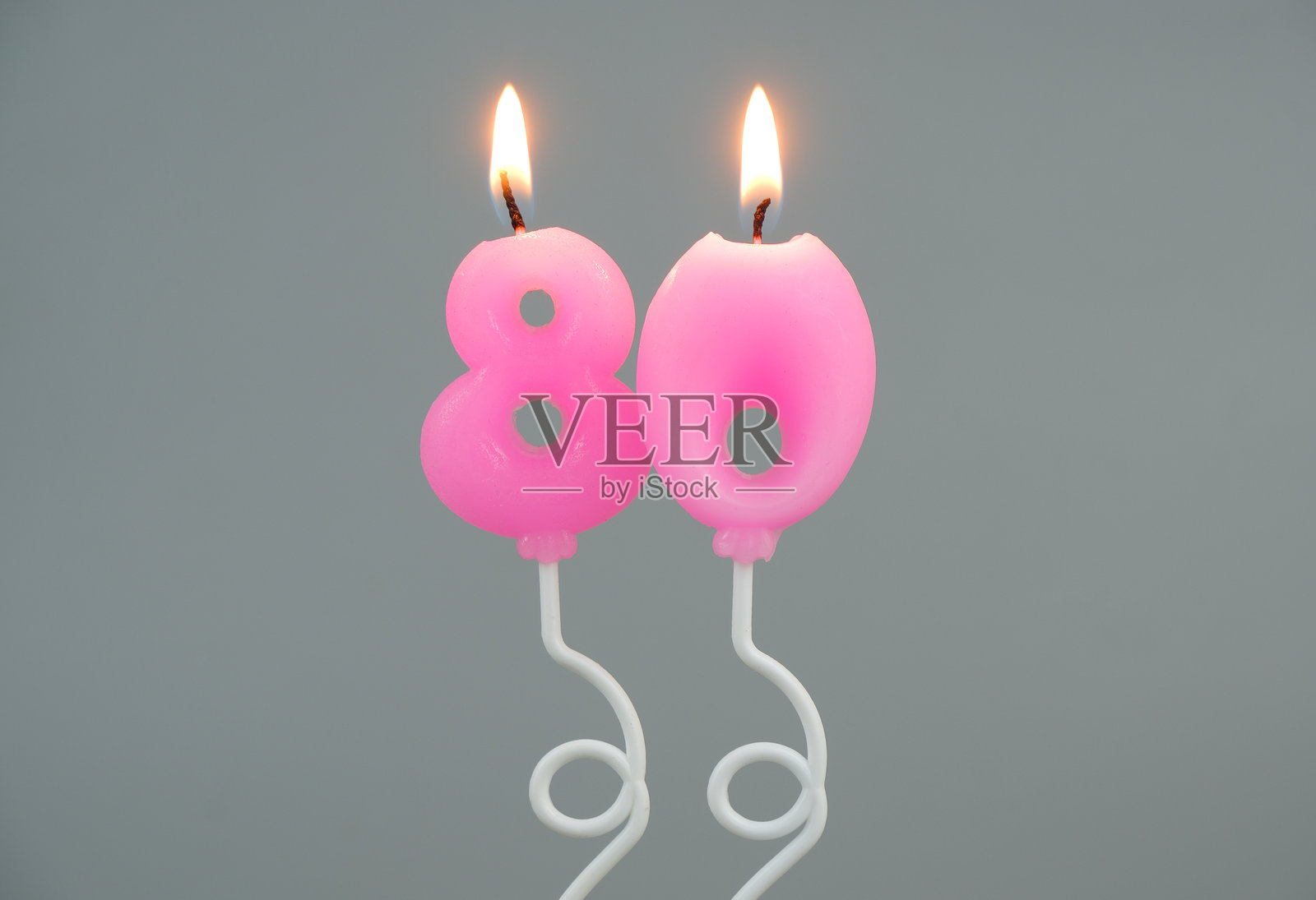 粉色气球形状的生日蜡烛，背景为灰色，数字80照片摄影图片