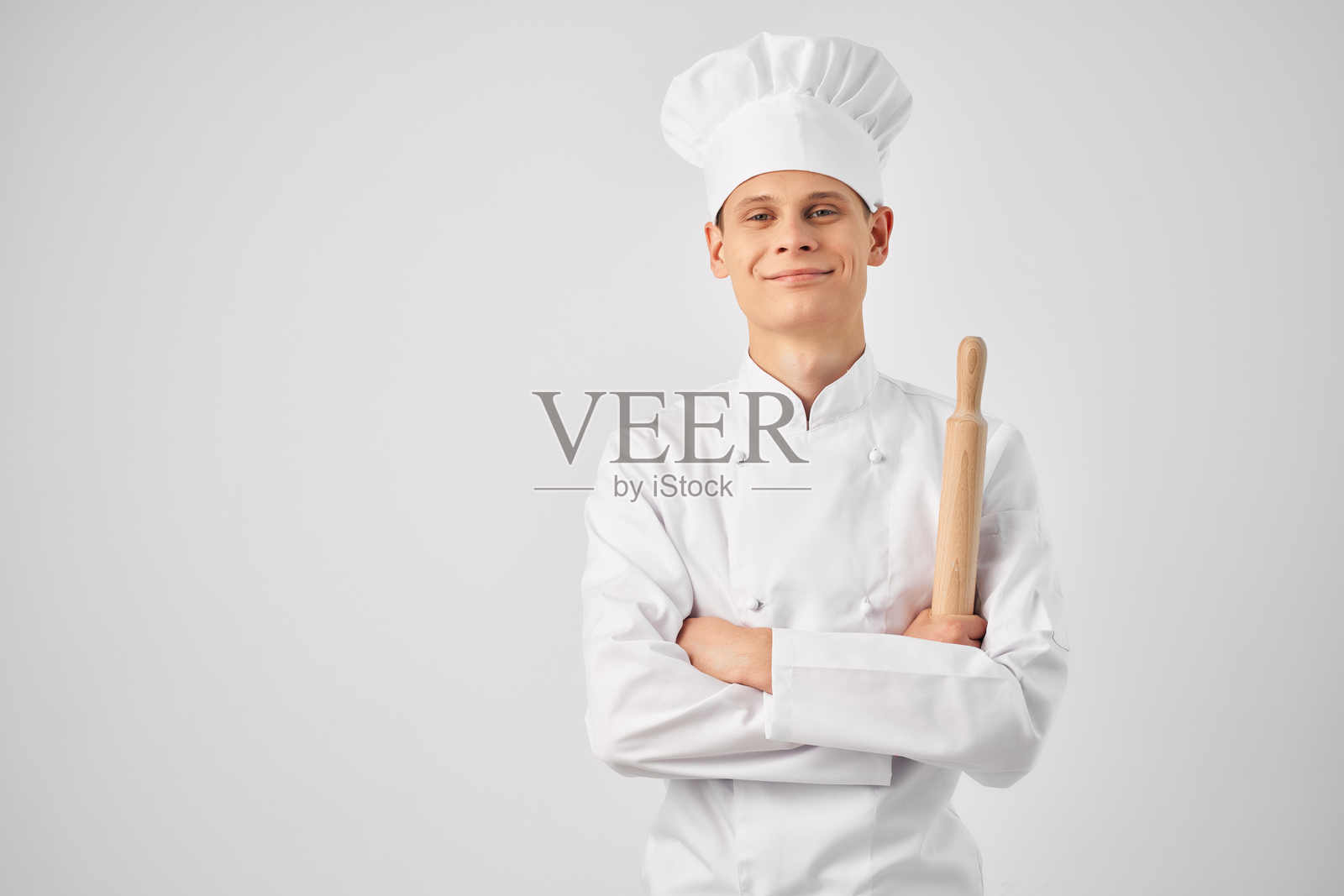 穿着厨师制服的男人在餐厅厨房里烹饪照片摄影图片