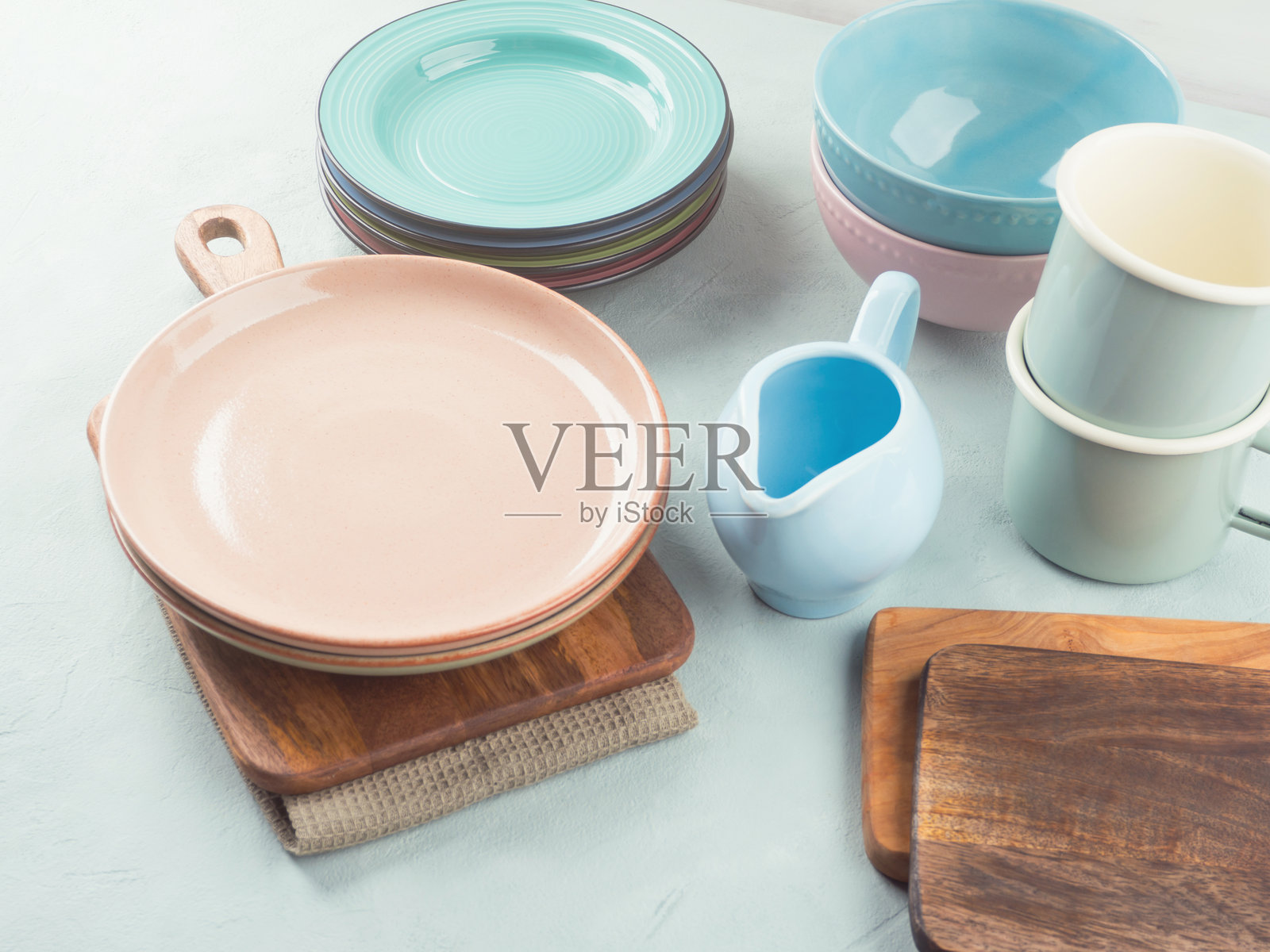 一套粉色和蓝色的柔和餐具，背景为青绿色照片摄影图片