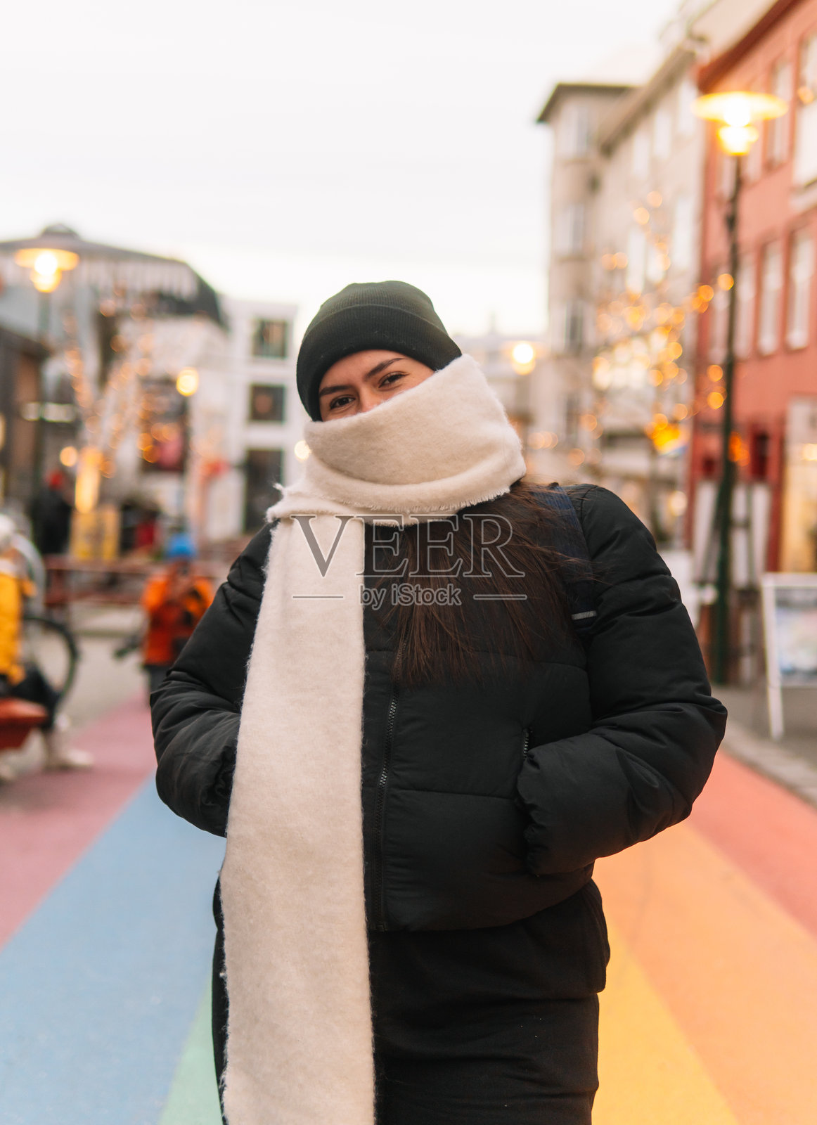 游客在雷克雅未克市中心用围巾遮住脸部。照片摄影图片