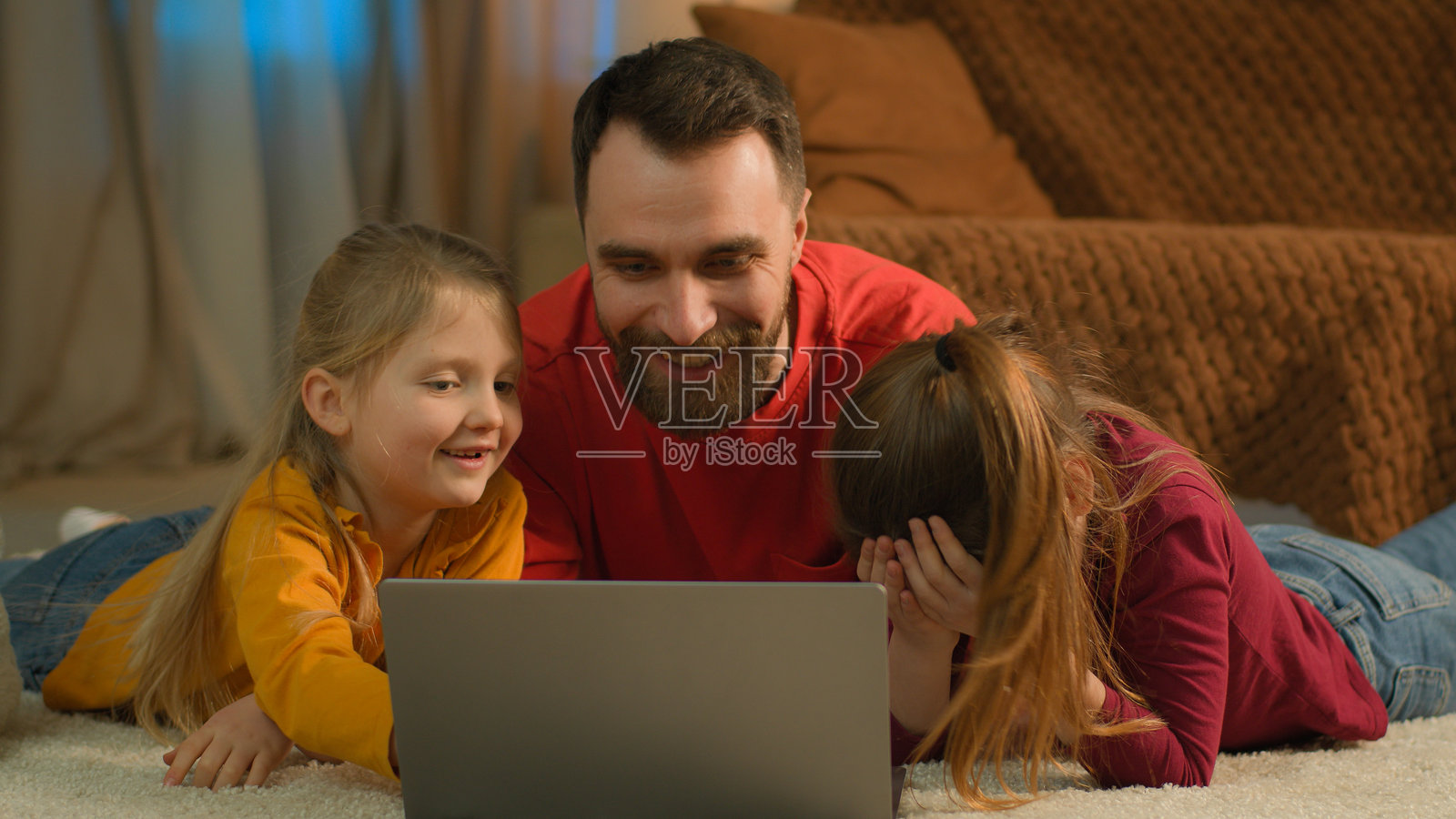 白人父亲与女儿们在家中使用电脑，作为单亲爸爸教导女儿们，帮助她们解决在线教育和学校作业中的难题。照片摄影图片