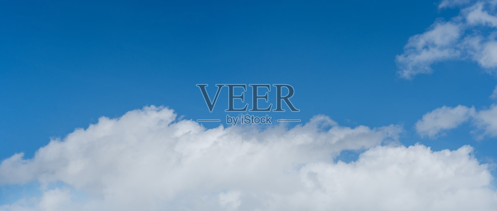 晴朗的蓝天上飘着蓬松的白色积云，阳光明媚，捕捉到了美丽春季气息的精髓。照片摄影图片