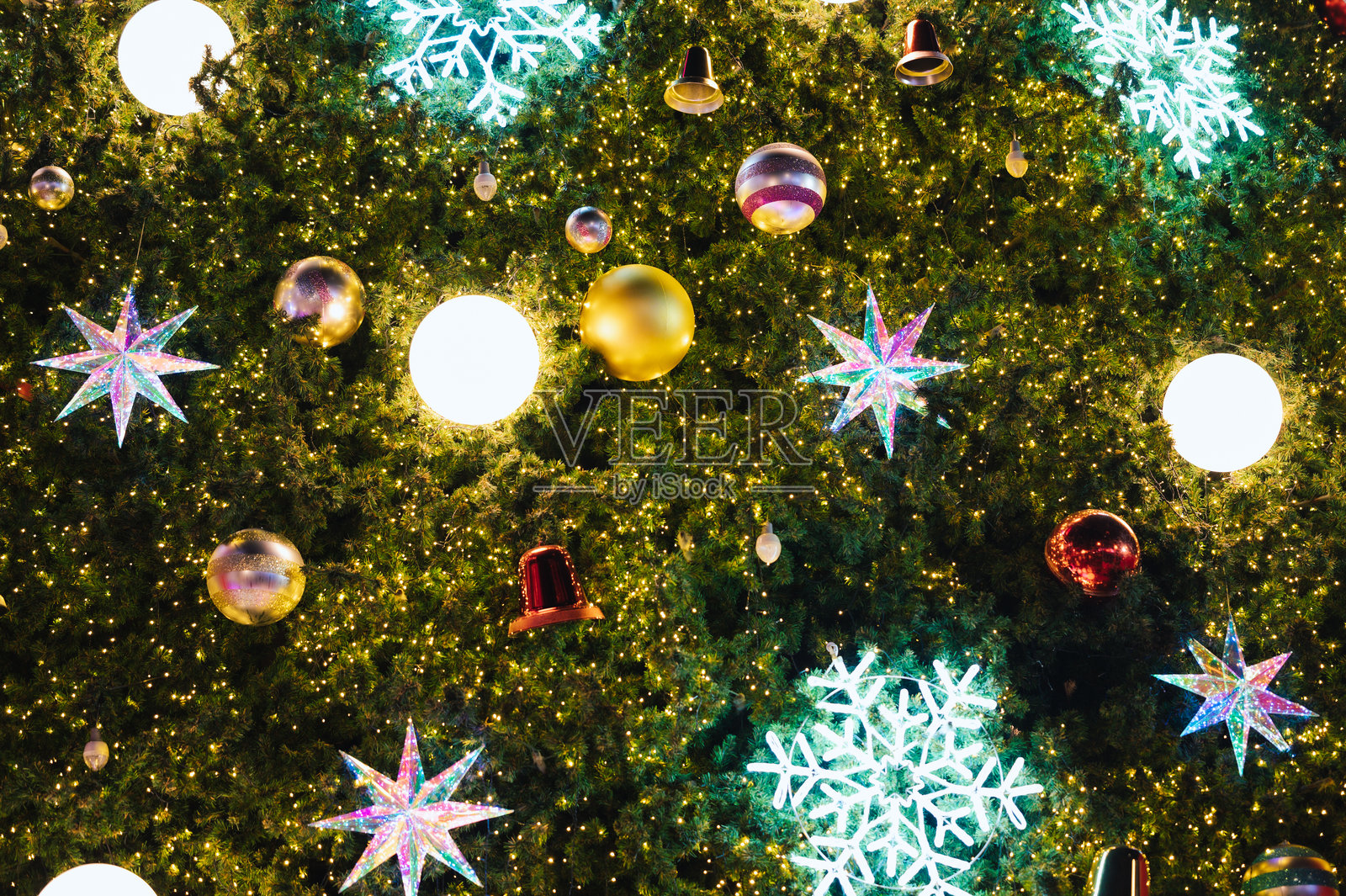 柔和的散景灯光突显出丰盛圣诞树上的五彩装饰品照片摄影图片