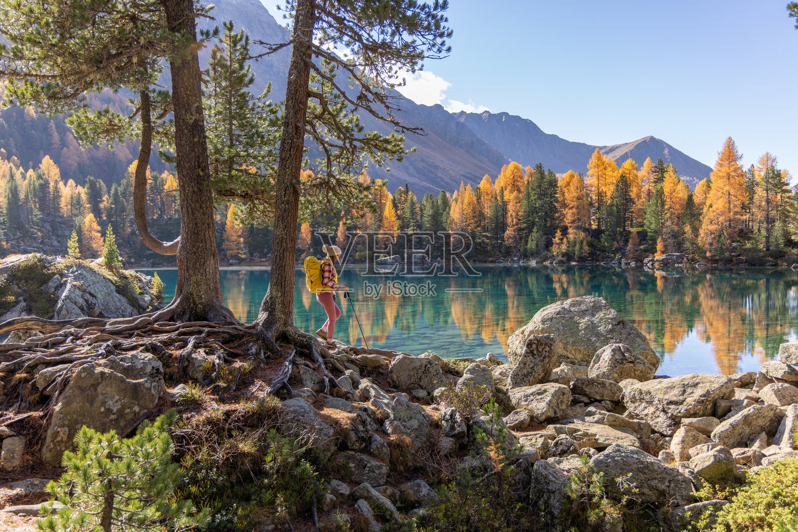 秋天在原始山湖旁的女性徒步旅行者照片摄影图片