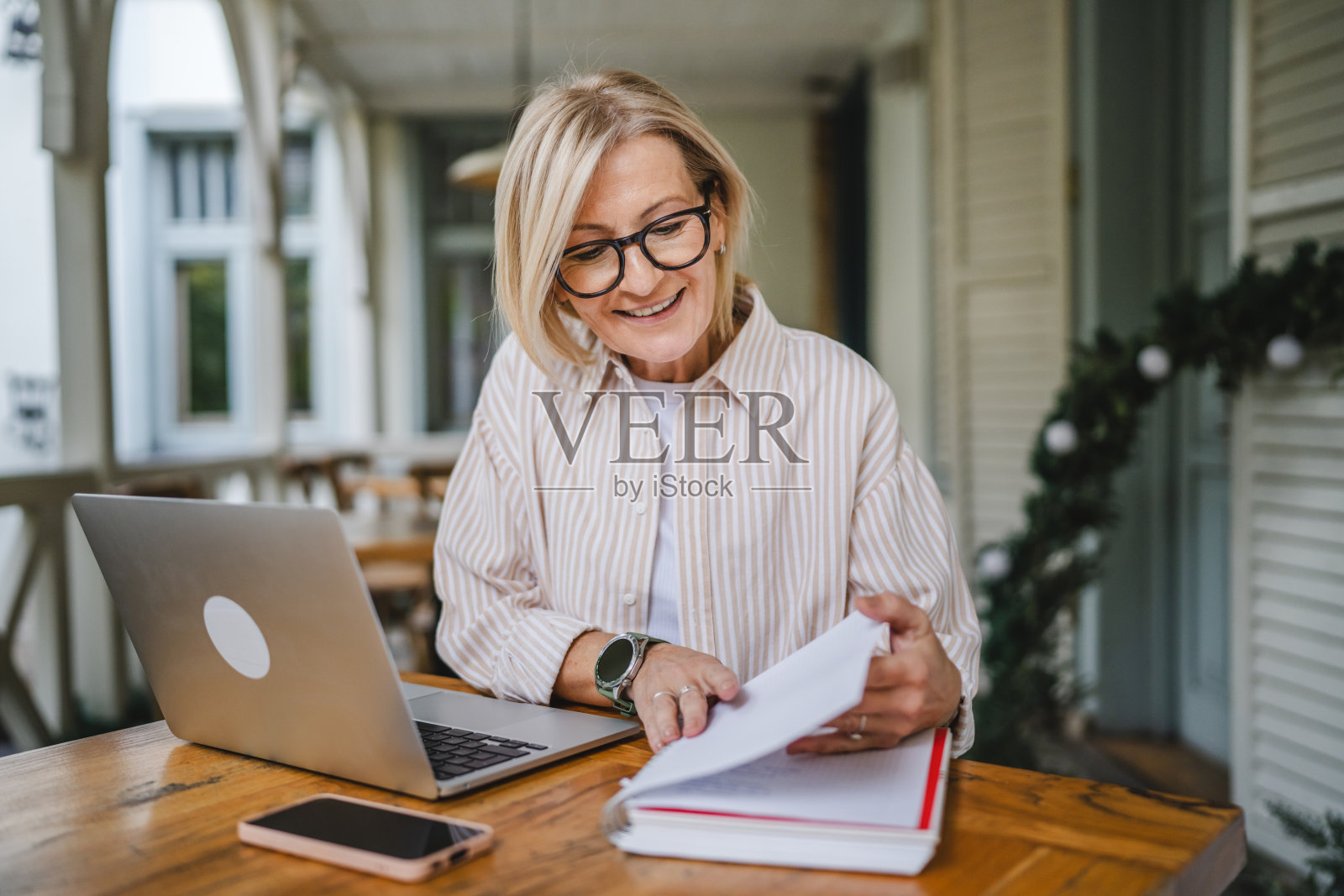 成熟的女性企业家在餐厅露台上使用笔记本电脑工作照片摄影图片