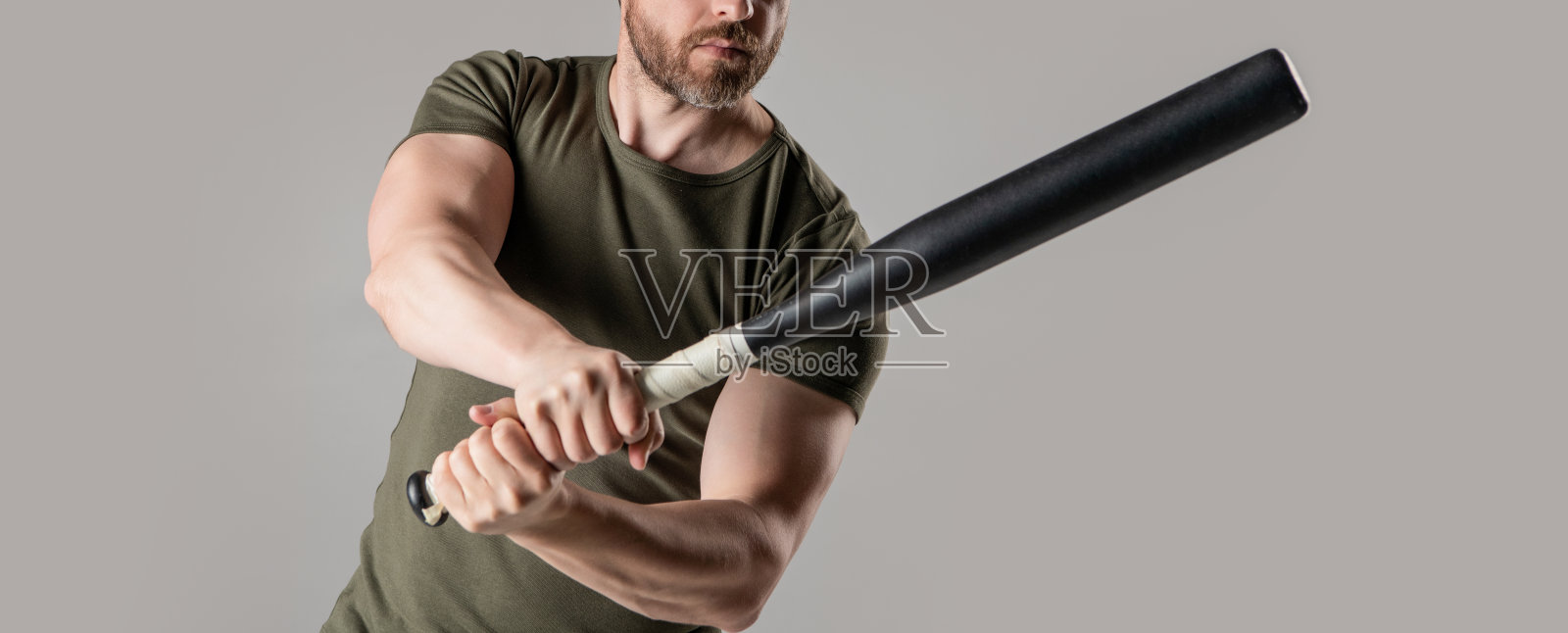 愤怒的男人用棒球棍表达愤怒的特写视图，背景为灰色。照片摄影图片
