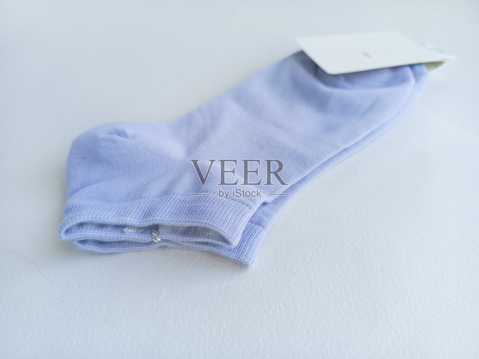 新蓝色袜子特写，带标签，背景为白色。广告背景，留有文本空间。照片摄影图片