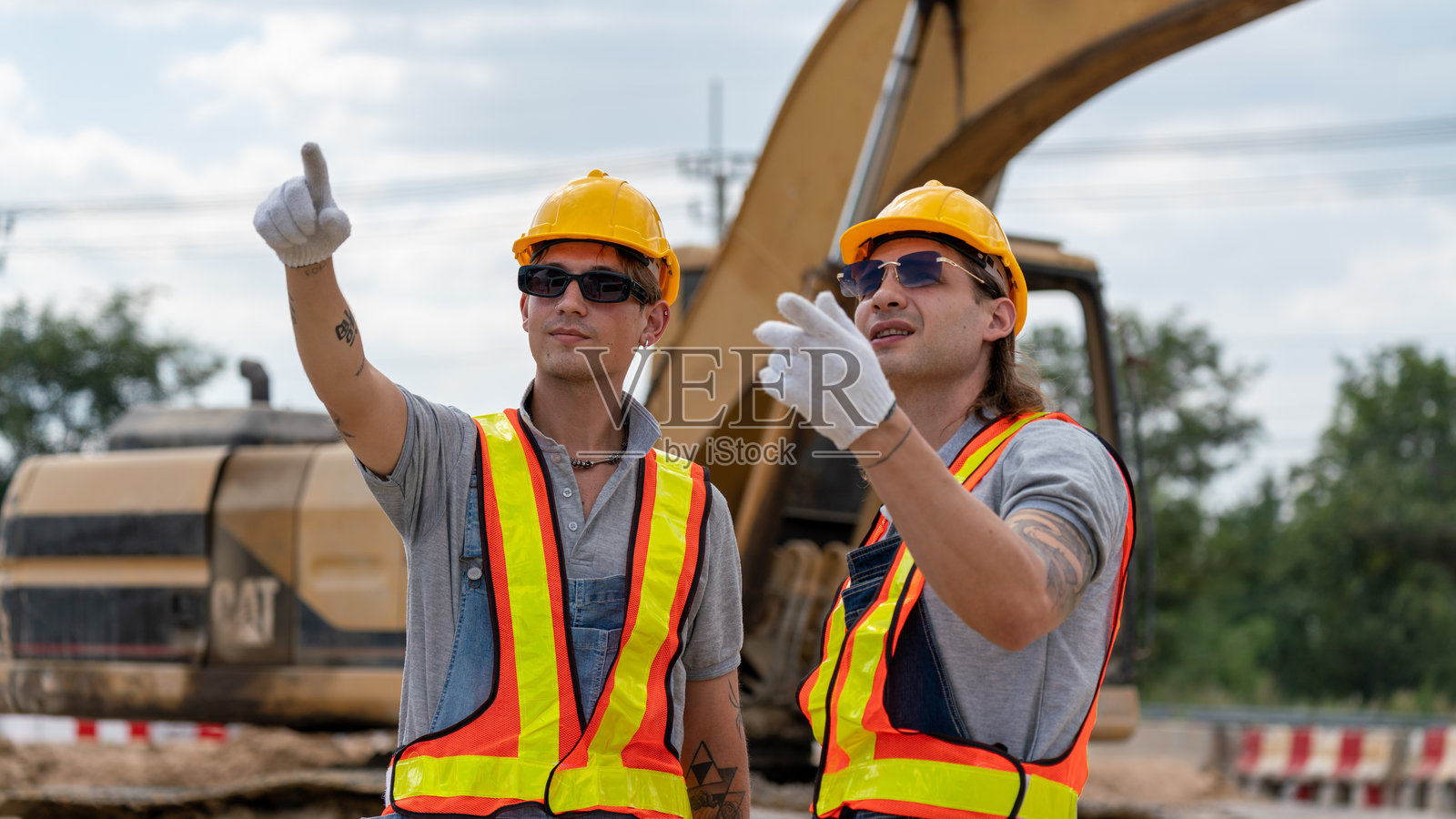 白人土木工程师、建筑师或建筑工人穿着安全服，在工地上检查建筑施工并核对蓝图或绘图计划。照片摄影图片