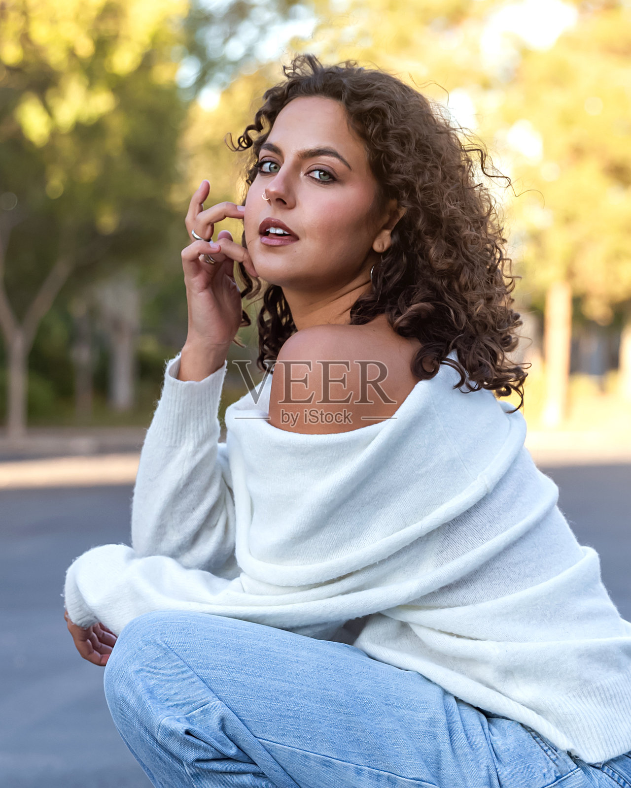 年轻女性穿着舒适的白色露肩毛衣照片摄影图片