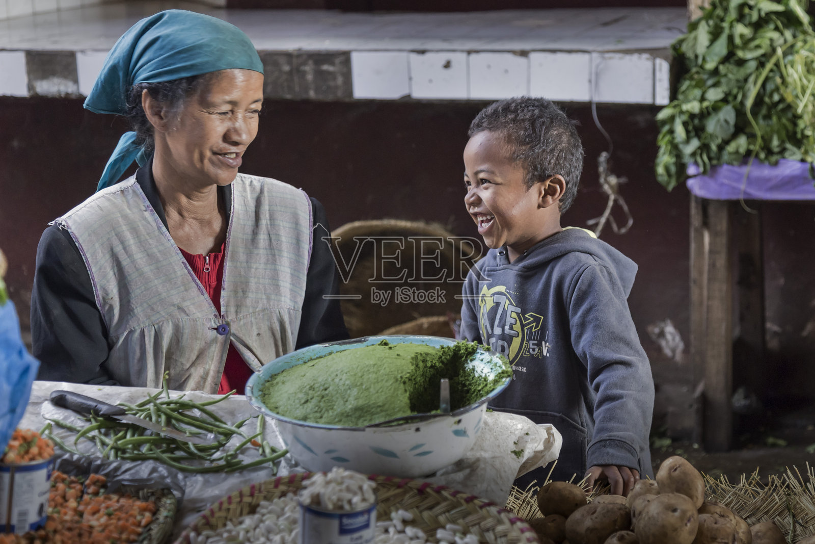 马达加斯加市场上，马达加斯加小孩与妈妈开心地笑着照片摄影图片