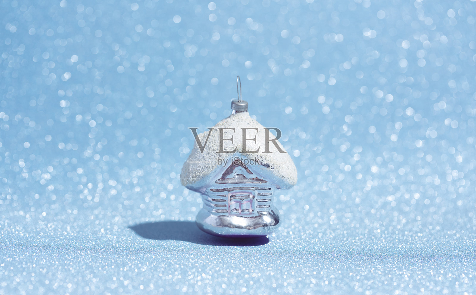 圣诞玻璃玩具童话屋，背景为闪亮的蓝色。照片摄影图片