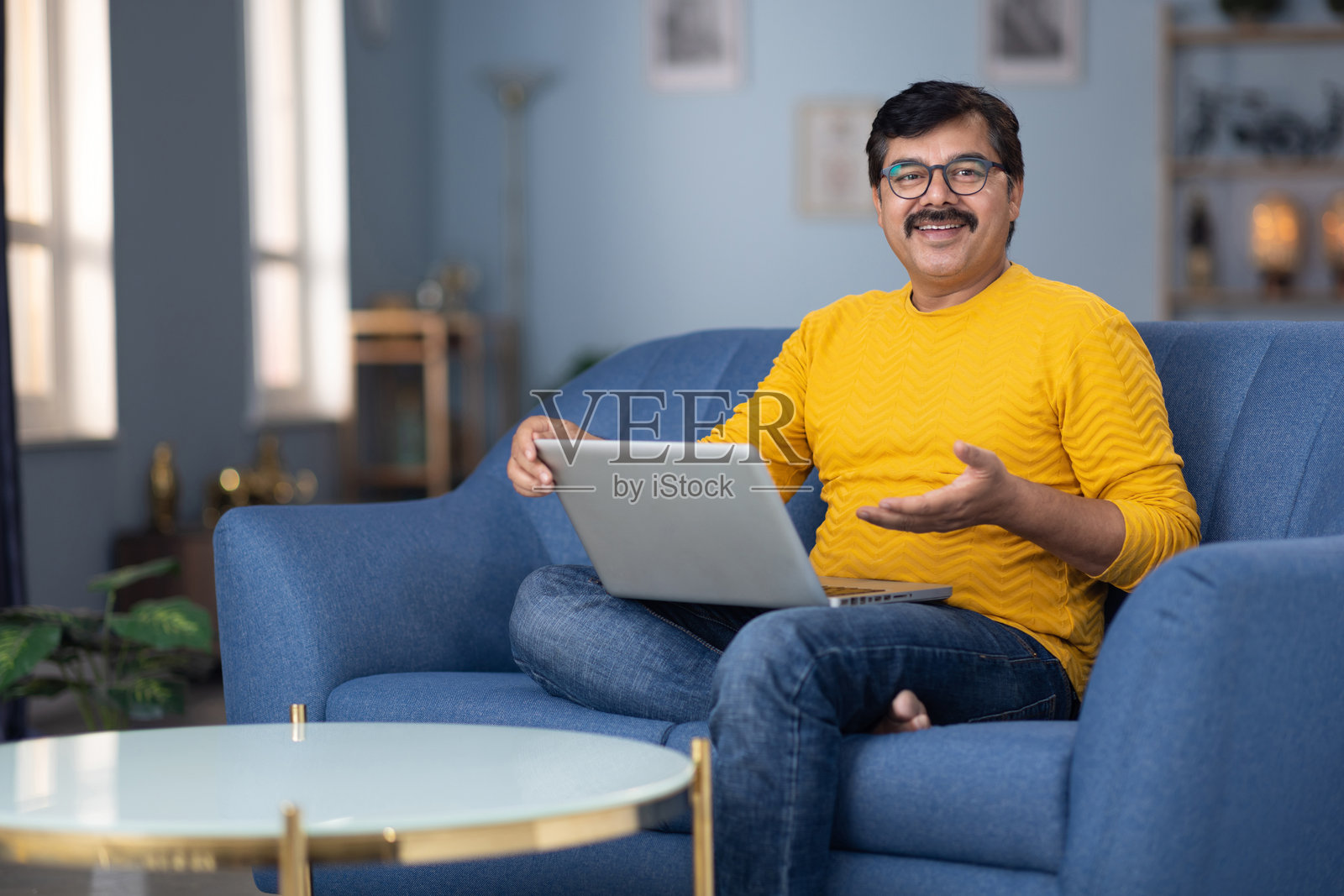 中年男子在家沙发上使用笔记本电脑的库存照片照片摄影图片