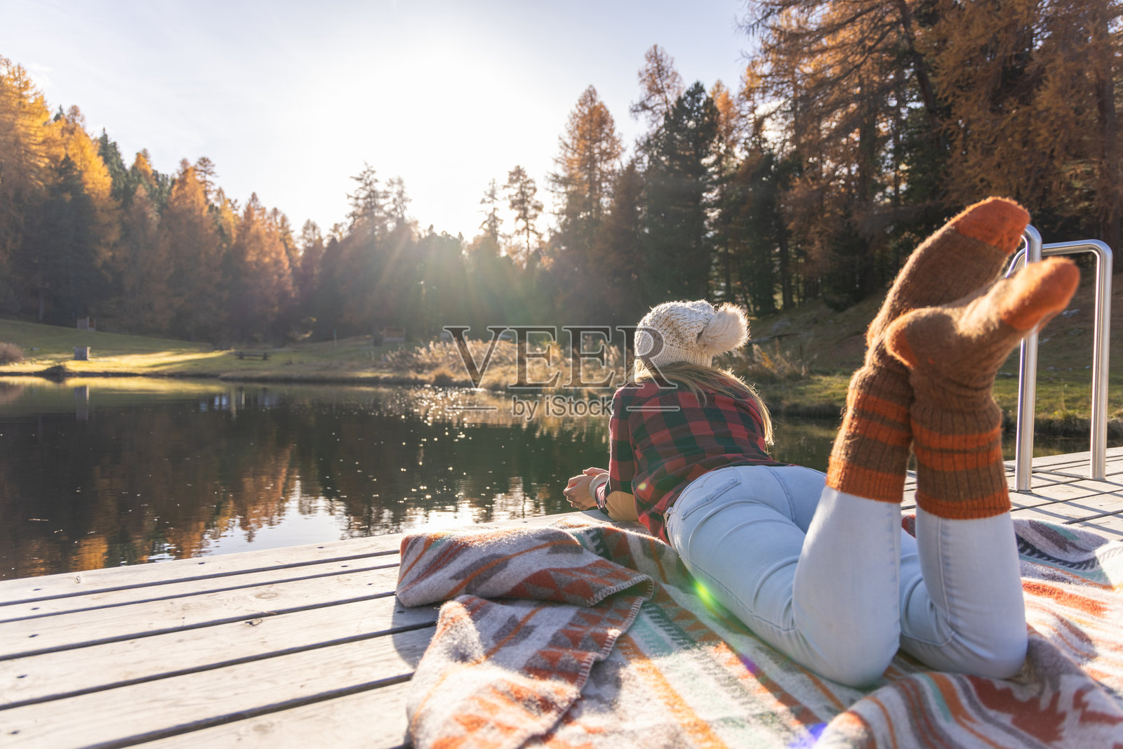 秋日宁静：女人在湖边码头放松照片摄影图片